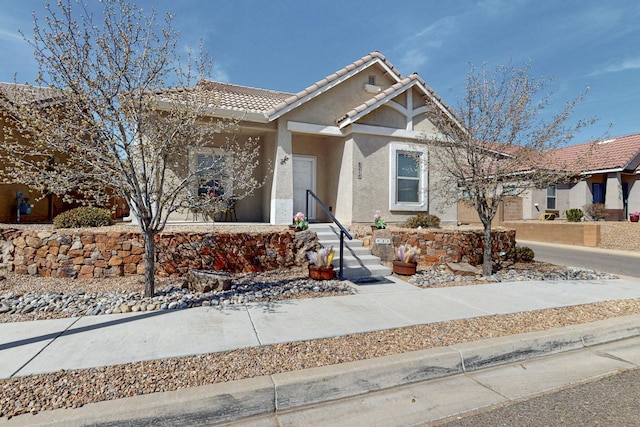 view of front facade with a tiled roof and stucco siding