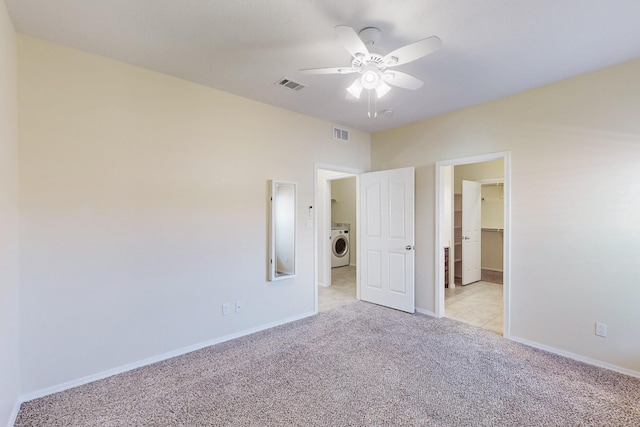 unfurnished bedroom featuring light carpet, visible vents, washer / clothes dryer, and baseboards