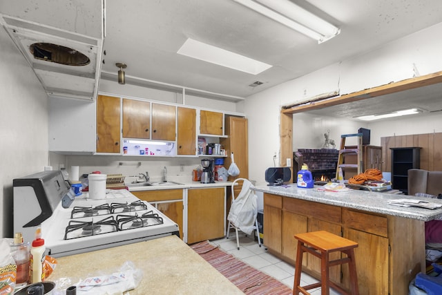 kitchen featuring open shelves, a sink, light countertops, and white range with gas cooktop