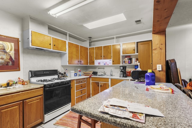 kitchen featuring open shelves, a skylight, brown cabinets, and white range with gas cooktop