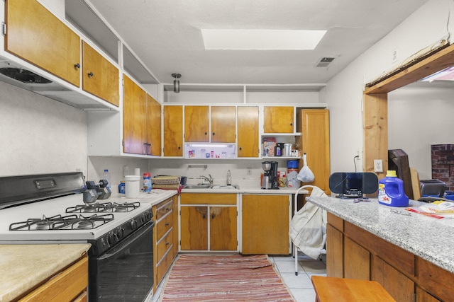 kitchen featuring a sink, visible vents, light countertops, open shelves, and gas stove