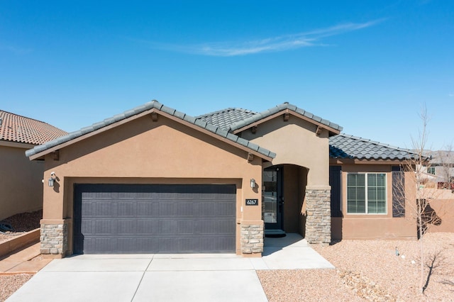 view of front of property featuring stone siding, a tiled roof, an attached garage, and stucco siding