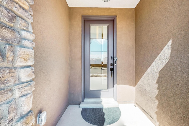 doorway to property featuring stucco siding