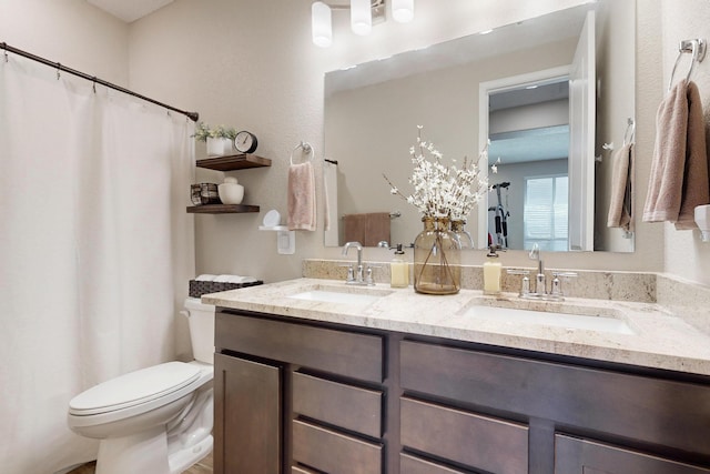 full bath featuring a sink, toilet, and double vanity