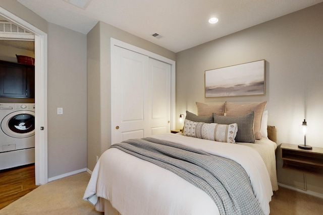 carpeted bedroom with recessed lighting, visible vents, baseboards, a closet, and washer / dryer