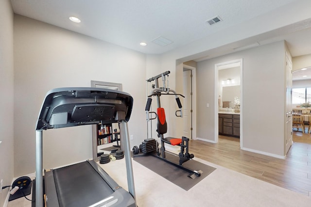 exercise room featuring baseboards, light wood finished floors, visible vents, and recessed lighting