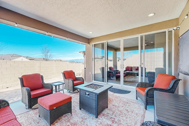 view of patio featuring an outdoor living space with a fire pit and fence