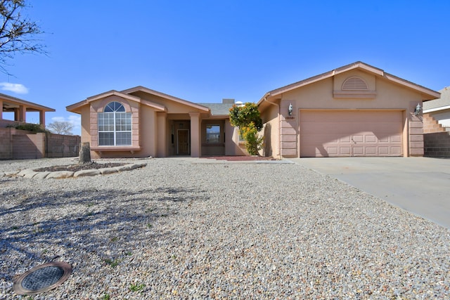 single story home featuring a garage, fence, concrete driveway, and stucco siding