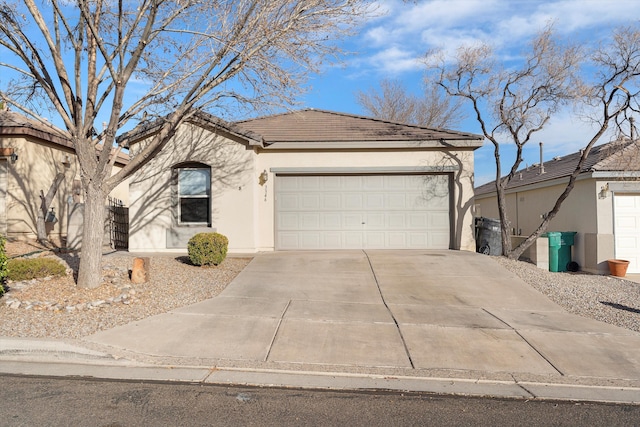 ranch-style home featuring driveway, a tiled roof, an attached garage, and stucco siding