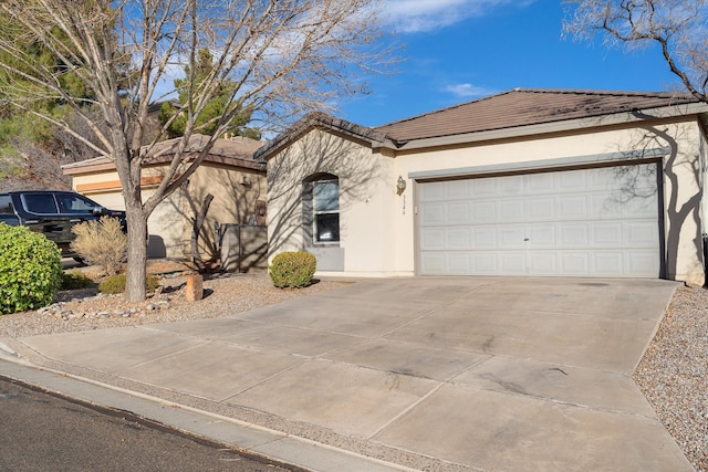 single story home with a tile roof, driveway, an attached garage, and stucco siding