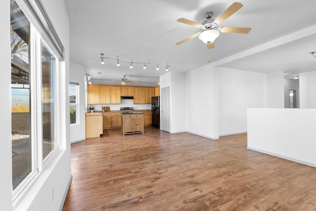 kitchen with open floor plan, stainless steel range with electric cooktop, black refrigerator with ice dispenser, and wood finished floors