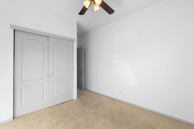 unfurnished bedroom with a ceiling fan, a closet, carpet flooring, and baseboards