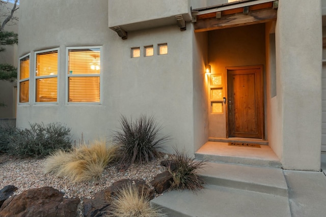 doorway to property featuring stucco siding