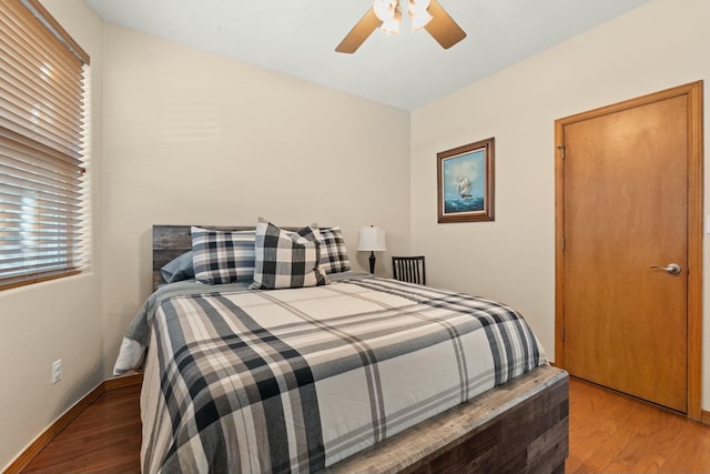 bedroom featuring a ceiling fan, baseboards, and wood finished floors