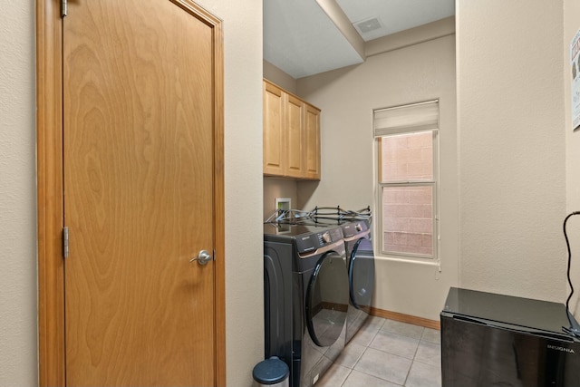 clothes washing area with cabinet space, light tile patterned floors, baseboards, visible vents, and washer and dryer