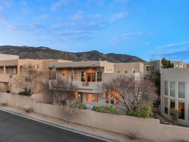 exterior space featuring a mountain view and stucco siding