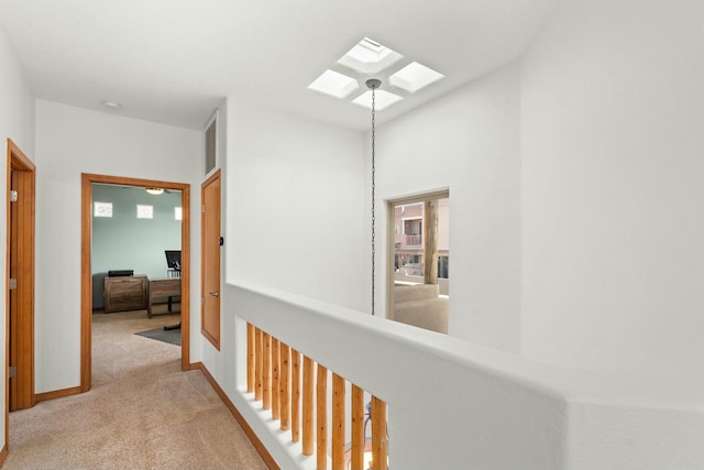 corridor with carpet, a skylight, visible vents, and baseboards