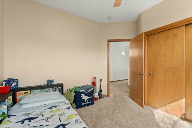 carpeted bedroom featuring a closet, a ceiling fan, and baseboards