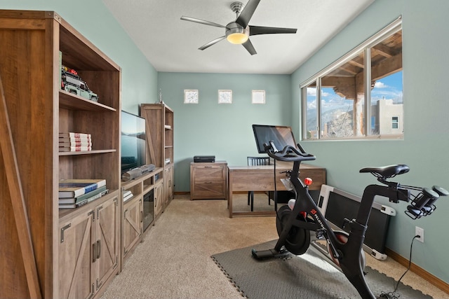 workout area with light carpet, ceiling fan, and baseboards