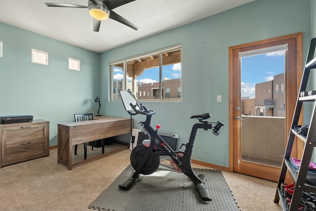 exercise area featuring ceiling fan, baseboards, and light colored carpet