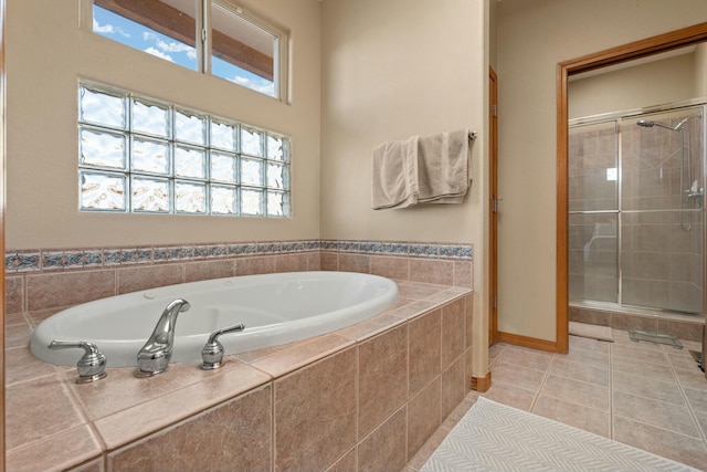 full bath featuring tile patterned flooring, a garden tub, and a shower stall