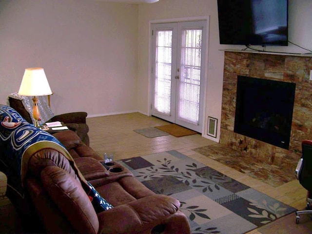 living room with a high end fireplace, french doors, baseboards, and wood finished floors