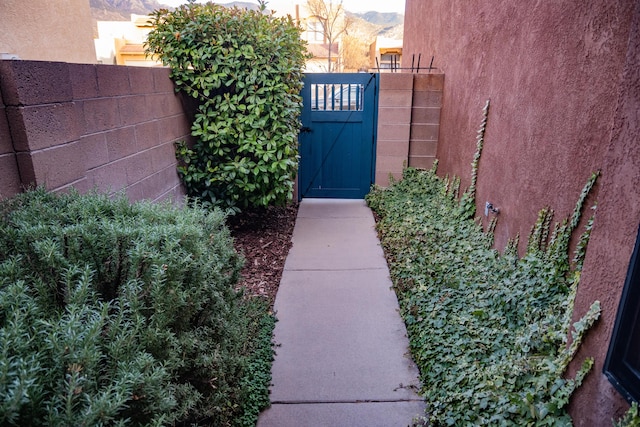 exterior space with fence, a gate, and stucco siding