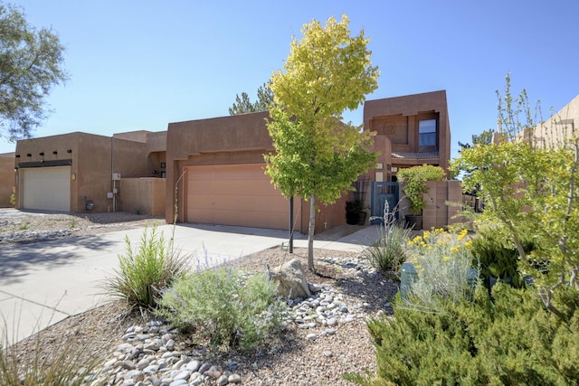 adobe home with a garage, driveway, and stucco siding