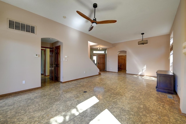 empty room featuring a ceiling fan, visible vents, arched walkways, and baseboards