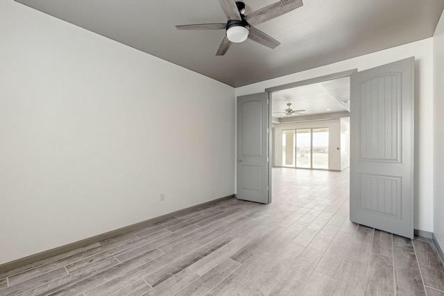 unfurnished room featuring light wood-type flooring, ceiling fan, and baseboards