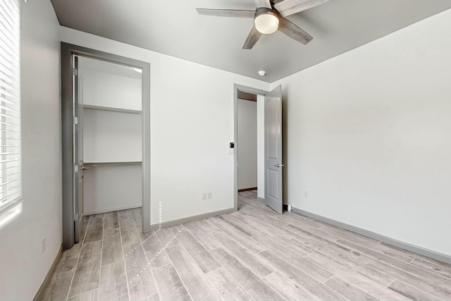 unfurnished bedroom featuring baseboards, a closet, a ceiling fan, and light wood-style floors