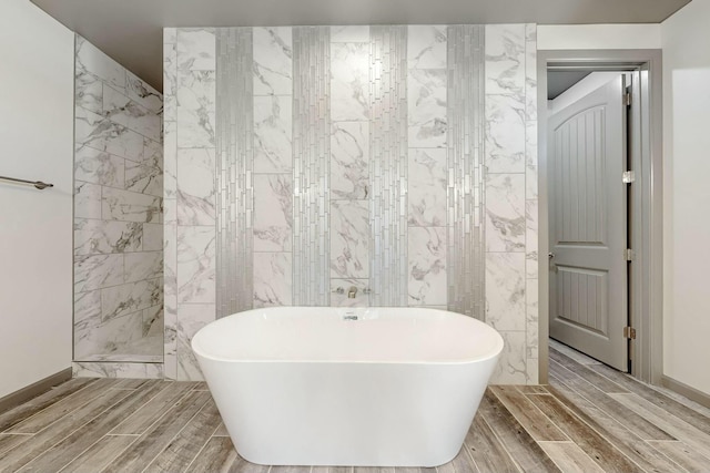 bathroom featuring wood finish floors, a freestanding bath, tile walls, and walk in shower