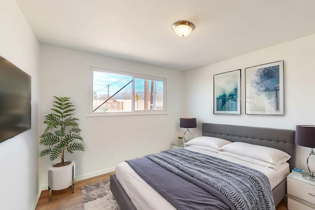 bedroom with baseboards and wood finished floors