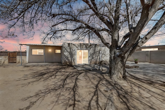 view of front of house with stucco siding and fence