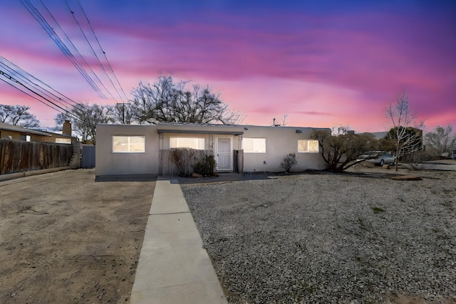 view of front of property with fence and stucco siding