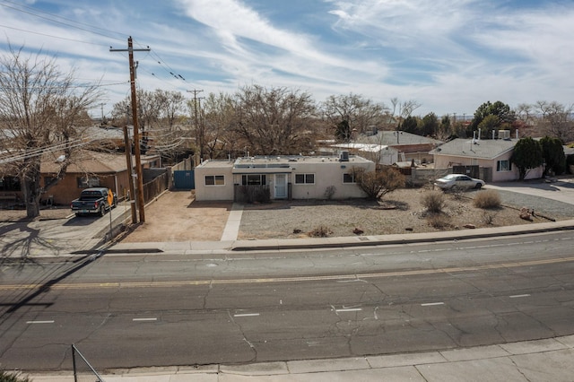 view of front of property with a fenced front yard, driveway, and stucco siding