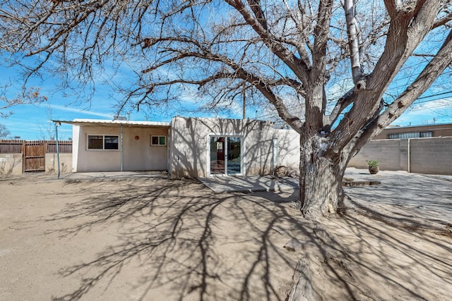 back of property with fence and stucco siding