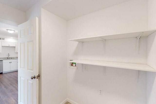 laundry room featuring hookup for a washing machine, laundry area, dark wood-type flooring, a sink, and baseboards