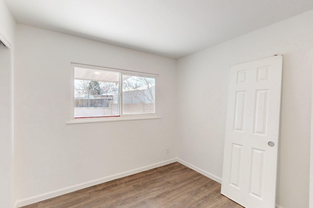 spare room with wood finished floors and baseboards