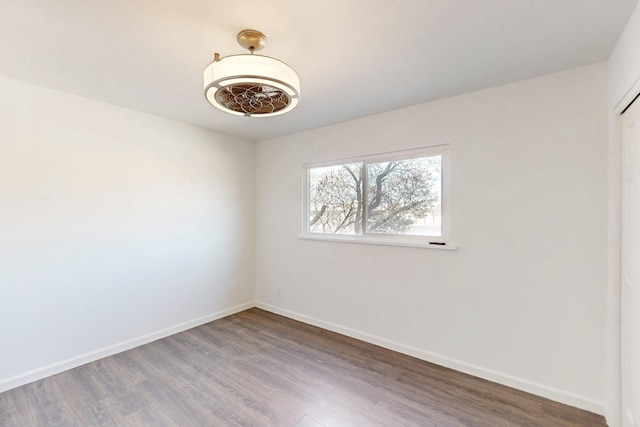 unfurnished room featuring baseboards and wood finished floors