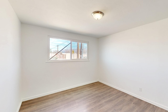 unfurnished room featuring baseboards and wood finished floors