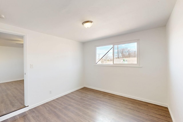 spare room featuring wood finished floors and baseboards