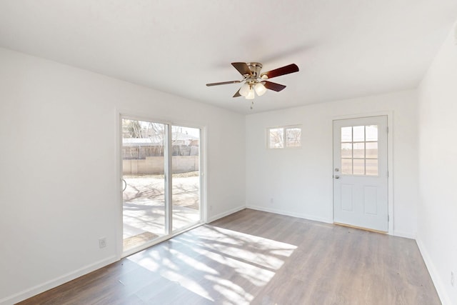 unfurnished room with ceiling fan, baseboards, and wood finished floors