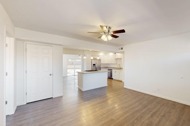 unfurnished living room with visible vents, ceiling fan, baseboards, and wood finished floors