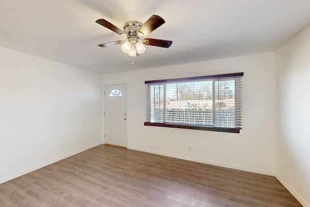 interior space featuring a ceiling fan, baseboards, and wood finished floors