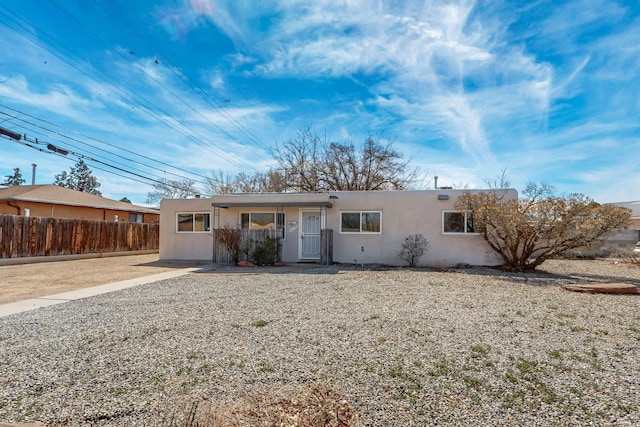 ranch-style house with fence and stucco siding