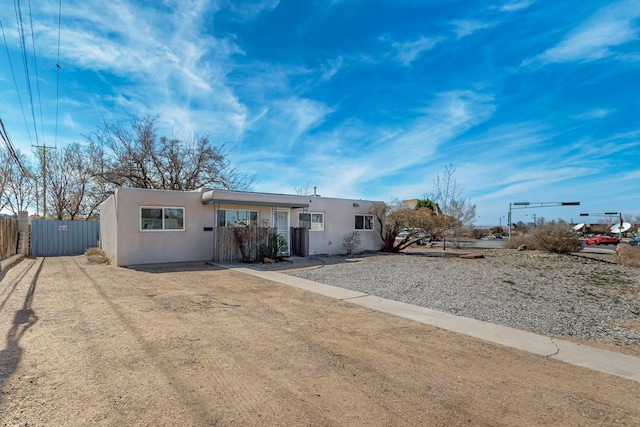 view of front of home with fence and stucco siding