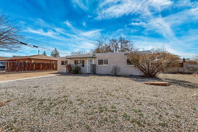 ranch-style house with fence and stucco siding