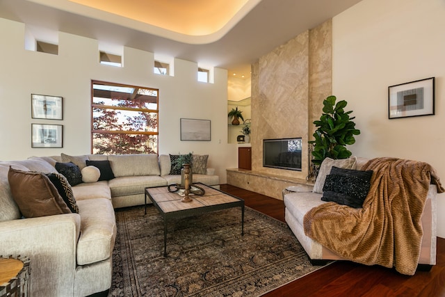 living room with dark wood-style floors, a premium fireplace, and plenty of natural light