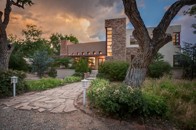 view of front facade with stone siding and stucco siding